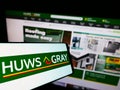 Smartphone with logo of British builders merchant company Huws Gray Limited on screen in front of website.