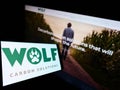 Smartphone with logo of company Wolf Carbon Solutions on screen in front of business website.