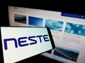 Smartphone with logo of Finnish oil company Neste Oyj on screen in front of business website. Royalty Free Stock Photo