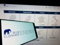 Smartphone with logo of German solar energy company Blue Elephant Energy AG on screen in front of website.