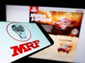 Smartphone with logo of Indian company Madras Rubber Factory (MRF Tyres) on screen in front of website.