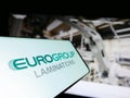 Smartphone with logo of Italian company EuroGroup Laminations S.p.A. on screen in front of website.