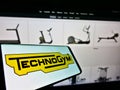 Smartphone with logo of Italian fitness equipment company Technogym S.p.A. on screen in front of business website.