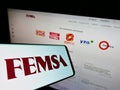 Smartphone with logo of Mexican company Fomento Econmico Mexicano (FEMSA) on screen with website.