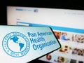 Smartphone with logo of Pan American Health Organization (PAHO) on screen in front of website. Royalty Free Stock Photo