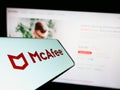 Smartphone with logo of security software company McAfee Corp. on screen in front of business website. Royalty Free Stock Photo