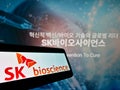 Smartphone with logo of South Korean biological company SK Bioscience Co. Ltd. on screen in front of webpage.