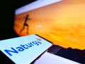 Smartphone with logo of Spanish energy company Naturgy Energy Group S.A. on screen in front of web page.