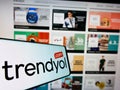 Smartphone with logo of Turkish online shopping platform Trendyol on screen in front of business website.