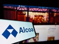 Smartphone with logo of US aluminium company Alcoa Corporation on screen in front of business website. Royalty Free Stock Photo