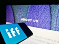 Smartphone with logo of US chemical company International Flavors and Fragrances Inc. (IFF) on screen with website.