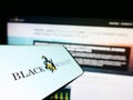 Smartphone with logo of US financial services company Black Knight Inc. on screen in front of website.