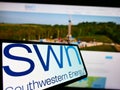 Smartphone with logo of US gas company Southwestern Energy Co. (SWN) on screen in front of business website. Royalty Free Stock Photo