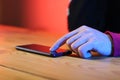 Smartphone lying on the table with a finger on the person`s display