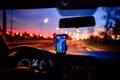 Smartphone with map on the screen in car. Automobile dashboard in night mode Royalty Free Stock Photo