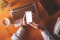 Smartphone mock up overhead shot, businessman holding mobile phone with blank screen over office desk Royalty Free Stock Photo