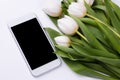 Smartphone mockup with a bouquet of white tulips. Device screen mock up for presentation or appl design