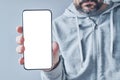 Smartphone mockup in male hand, casual adult man holding modern mobile phone device with blank white screen as copy space