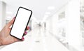 Smartphone mockup in woman hand with business centre background. Modern frameless smartphone mock up with blank white screen. Empt