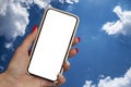 Smartphone mockup. A woman holds a smartphone in her hands against the backdrop of a beautiful sky with clouds Royalty Free Stock Photo