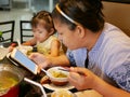 A smartphone in a mom`s hand being used and drawing all the mother`s attention from her little baby girl sitting on the same