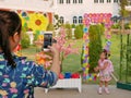 A smartphone in a mother`s hand taking a memorial photo of her little daughter`s first day of school semester - back to school