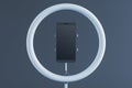 Smartphone mounted in a ring light on a dark background. 3D Rendering Royalty Free Stock Photo