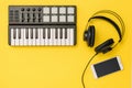 Smartphone, music mixer and headphones on bright yellow background. The concept of workplace organization. Royalty Free Stock Photo