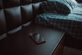 Smartphone on nightstand near bed in hotel room. Modern interior Royalty Free Stock Photo