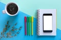 Smartphone, notebook, color pencils and coffee on blue paper background. Business start-up and back to schools concept Royalty Free Stock Photo