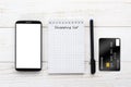 Smartphone, notebook and credit card on a white table Royalty Free Stock Photo