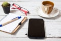 Smartphone with notebook and cupon wooden table Royalty Free Stock Photo