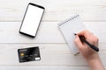 Smartphone, notebook, pen and credit card on a white table Royalty Free Stock Photo