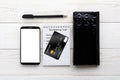 Smartphone, notebook, pen and credit card on a white table Royalty Free Stock Photo
