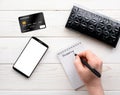 Smartphone, notebook, pen and credit card on a white table Royalty Free Stock Photo