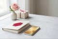 Smartphone and notebook on table with pink rose and gift box Royalty Free Stock Photo