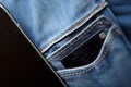 Smartphone in pocket jeans closeup with small card. Generate Ai