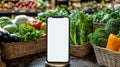 A smartphone stands among fresh vegetables in vibrant grocery market during morning hours Royalty Free Stock Photo