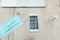Smartphone and protective mask on the office Desk. Royalty Free Stock Photo