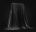 Smartphone prototype hidden under black cloth cover on dark background