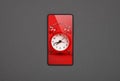 Smartphone with red alarm clock screen over grey Royalty Free Stock Photo