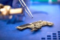 Smartphone repair. tweezers with microchip at mobile phone repairing