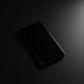A smartphone rests on a dark surface, with soft, focused lighting highlighting its slee Royalty Free Stock Photo
