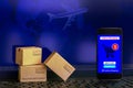 Smartphone runs an online shopping app with cardboard boxes on n