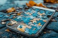 Smartphone screen covered with puzzle pieces creating complex pattern, lying on ground with scattered pieces Royalty Free Stock Photo