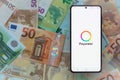 smartphone screen with digital payment service Payoneer mobile application on euro banknotes background