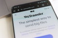 Smartphone screen displaying WeTransfer homepage with file sharing interface and terms of service message. Royalty Free Stock Photo