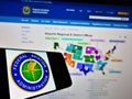 Smartphone with seal of American agency Federal Aviation Administration (FAA) on screen in front of website.