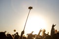 A smartphone on a self-stick, a summer music festival at sunset Royalty Free Stock Photo