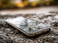 Smartphone with shattered screen lying on rough asphalt surface illustrating accidental damage and the consequences of dropping Royalty Free Stock Photo